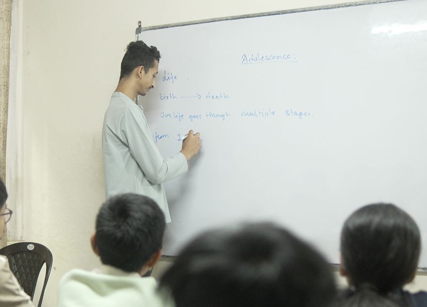 A teacher writing the lesson on the whiteboard